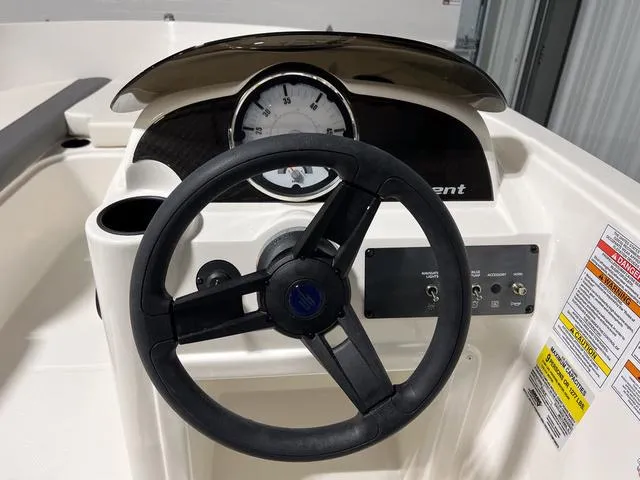 Slide: The Image of 2024 Bayliner E18 LTD boat steering console with speedometer and control panel. - 18