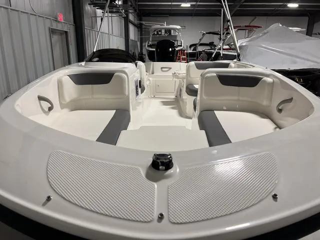 Slide: The Image of 2024 Bayliner E18 LTD boat interior with seating, in a showroom. - 4