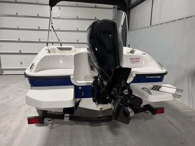 Slide: The Image of 2024 Bayliner E18 LTD boat rear view with outboard motor in storage. - 5