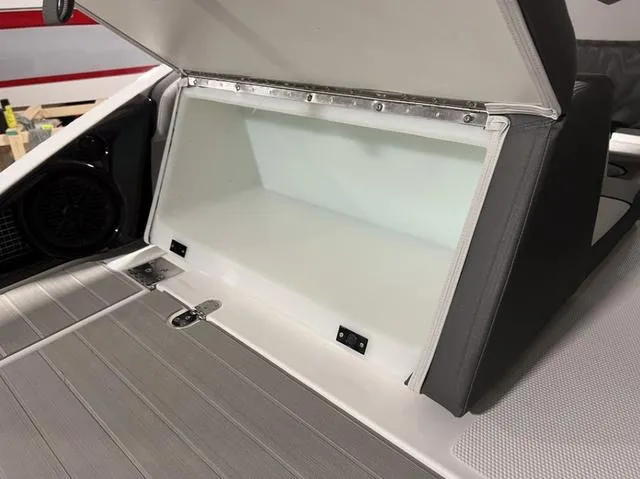 Slide: The Image of 2024 Yamaha Boats AR250 storage compartment with open lid. - 10