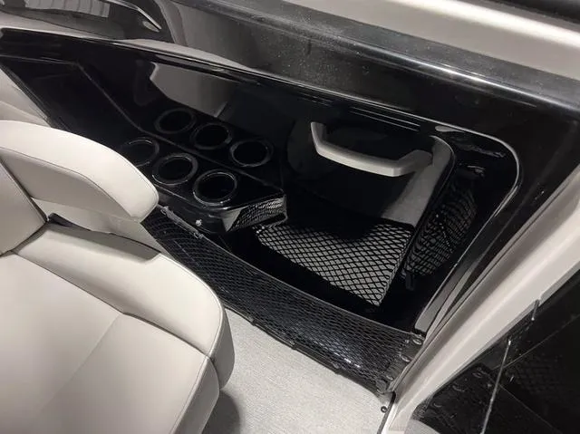 Slide: The Image of 2024 Yamaha Boats AR250 interior with cup holders and storage net. - 11