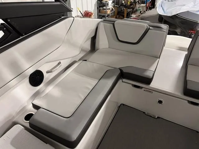 Slide: The Image of 2024 Yamaha Boats AR250 interior seating area with gray and white upholstery. - 17