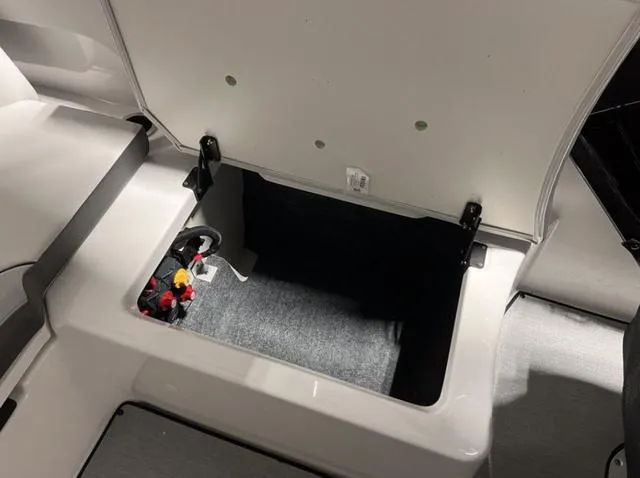 Slide: The Image of 2024 Yamaha Boats AR250 storage compartment with open lid. - 18