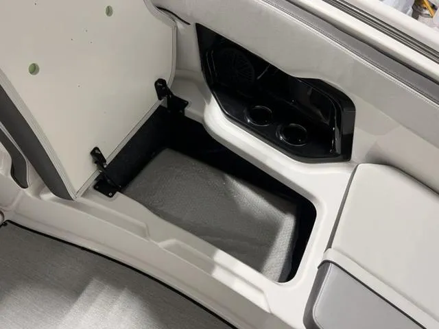 Slide: The Image of 2024 Yamaha Boats AR250 storage compartment with cup holders and speaker. - 19