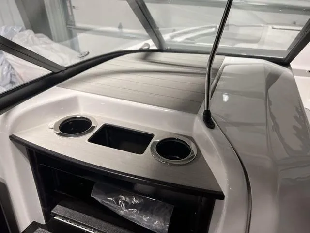 Slide: The Image of 2024 Yamaha Boats AR250 dashboard with cup holders and storage compartment. - 22