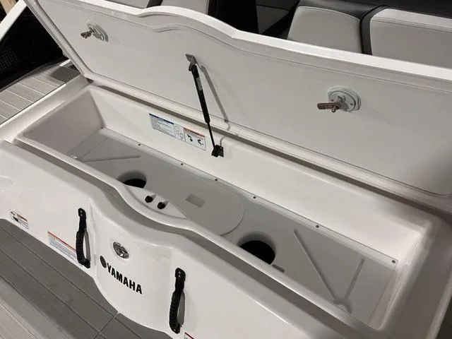Slide: The Image of 2024 Yamaha Boats AR250 storage compartment with open lid. - 27