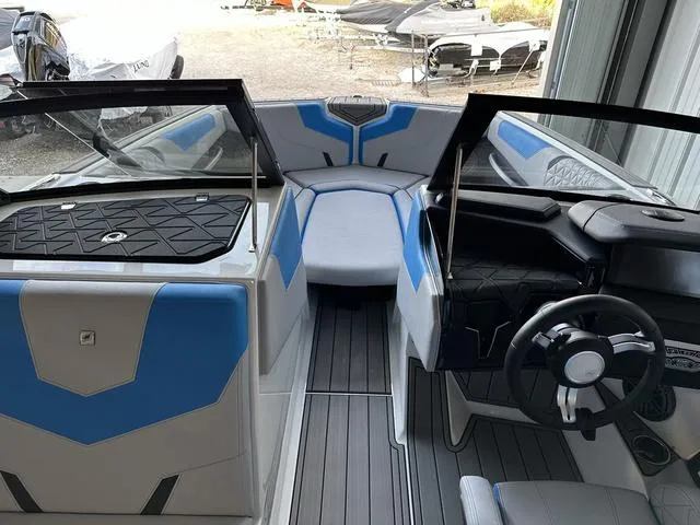 Slide: The Image of 2024 Nautique Super Air Nautique GS22 interior with blue and white seating and modern dashboard. - 13