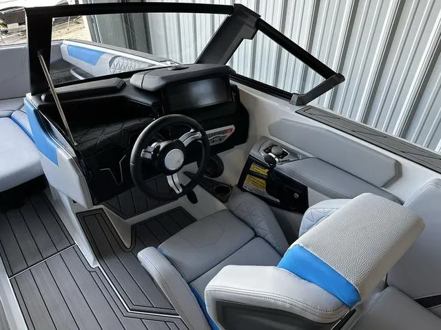 Slide: The Image of 2024 Nautique Super Air Nautique GS22 boat interior with modern dashboard and seating. - 18