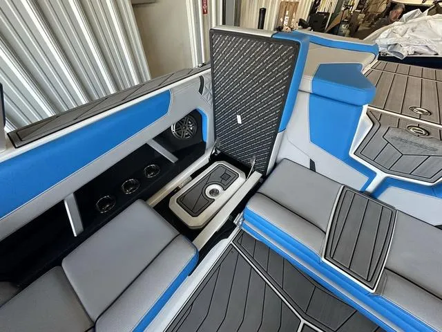 Slide: The Image of 2024 Nautique Super Air Nautique GS22 interior with blue and gray seating and storage compartments. - 20