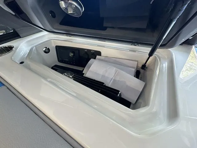 Slide: The Image of Storage compartment of 2024 Nautique Super Air Nautique GS22 boat with control panel. - 23