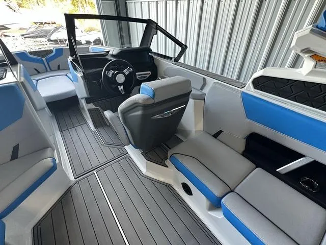 Slide: The Image of 2024 Nautique Super Air Nautique GS22 interior with blue and gray seating, modern dashboard. - 27
