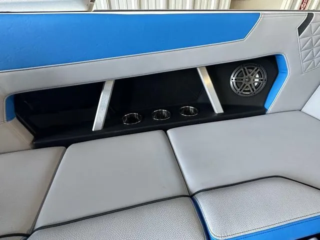 Slide: The Image of 2024 Nautique Super Air Nautique GS22 interior seating with cup holders and speaker. - 29