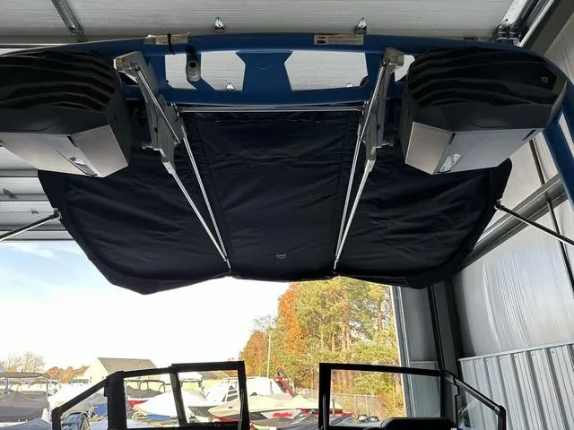 Slide: The Image of 2024 Nautique Super Air Nautique GS22 boat with black bimini top in storage. - 3