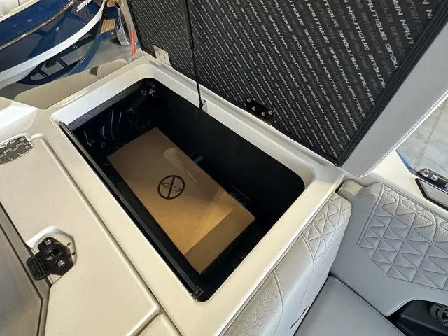 Slide: The Image of 2024 Nautique Super Air Nautique GS22 storage compartment with open lid. - 32