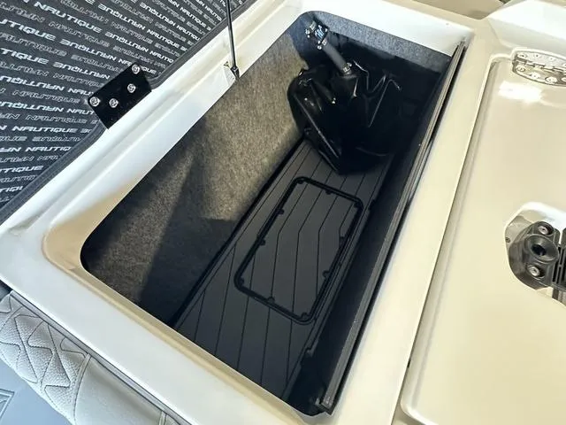 Slide: The Image of 2024 Nautique Super Air Nautique GS22 storage compartment with black interior. - 33