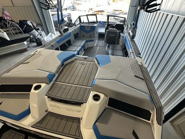 Slide: The Image of 2024 Nautique Super Air Nautique GS22 boat interior with gray and blue seating. - 36