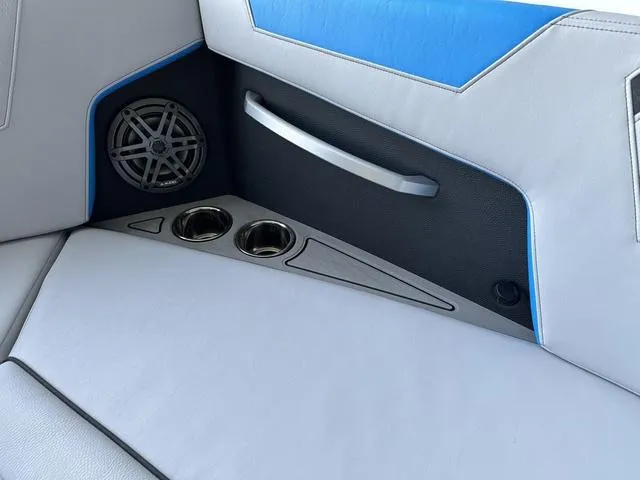 Slide: The Image of 2024 Nautique Super Air Nautique GS22 interior with speaker, cup holders, and handle. - 9