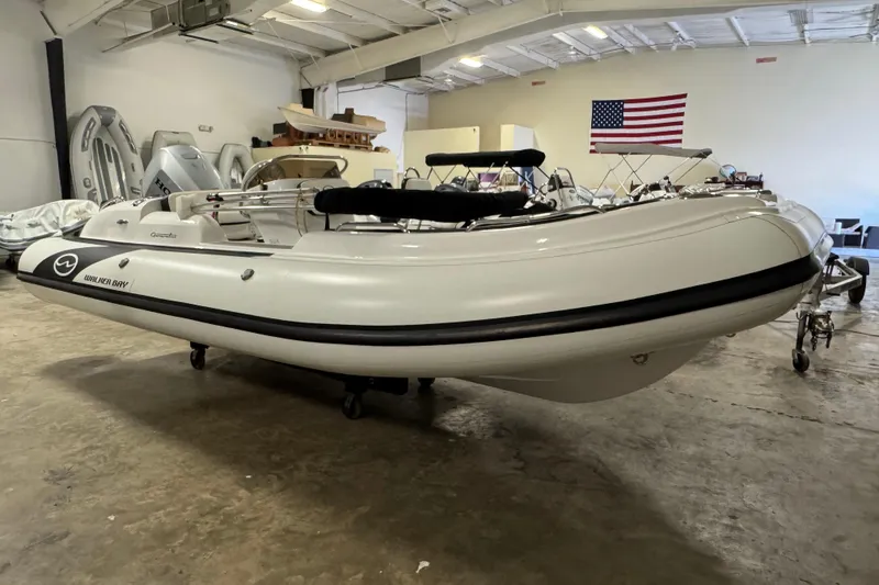 Slide: The Image of 2021 Walker Bay Generation 525 DLX inflatable boat in showroom with American flag. - 2