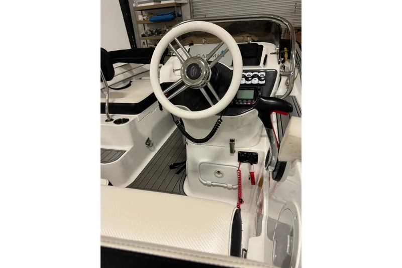 Slide: The Image of 2021 Walker Bay Generation 525 DLX boat cockpit with steering wheel and controls. - 3
