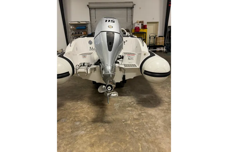 Slide: The Image of 2021 Walker Bay Generation 525 DLX boat with Honda 115 outboard motor in a garage. - 5