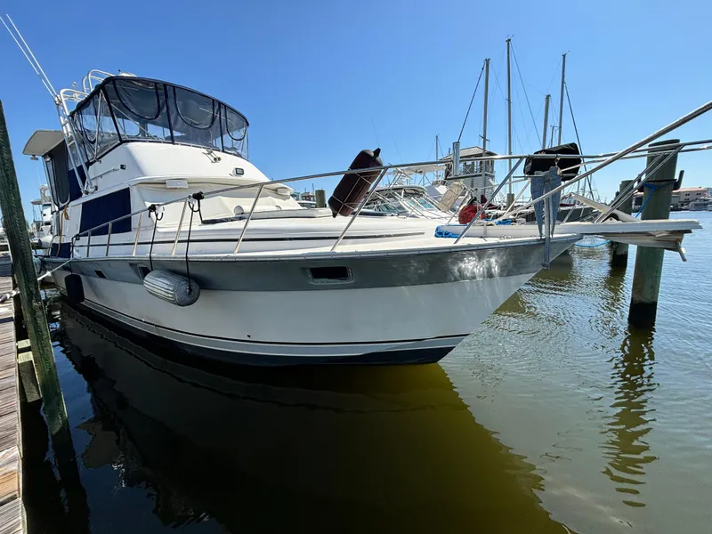 Slide: The Image of 1987 Silverton AFT CABIN yacht docked in marina under clear blue sky. - 0