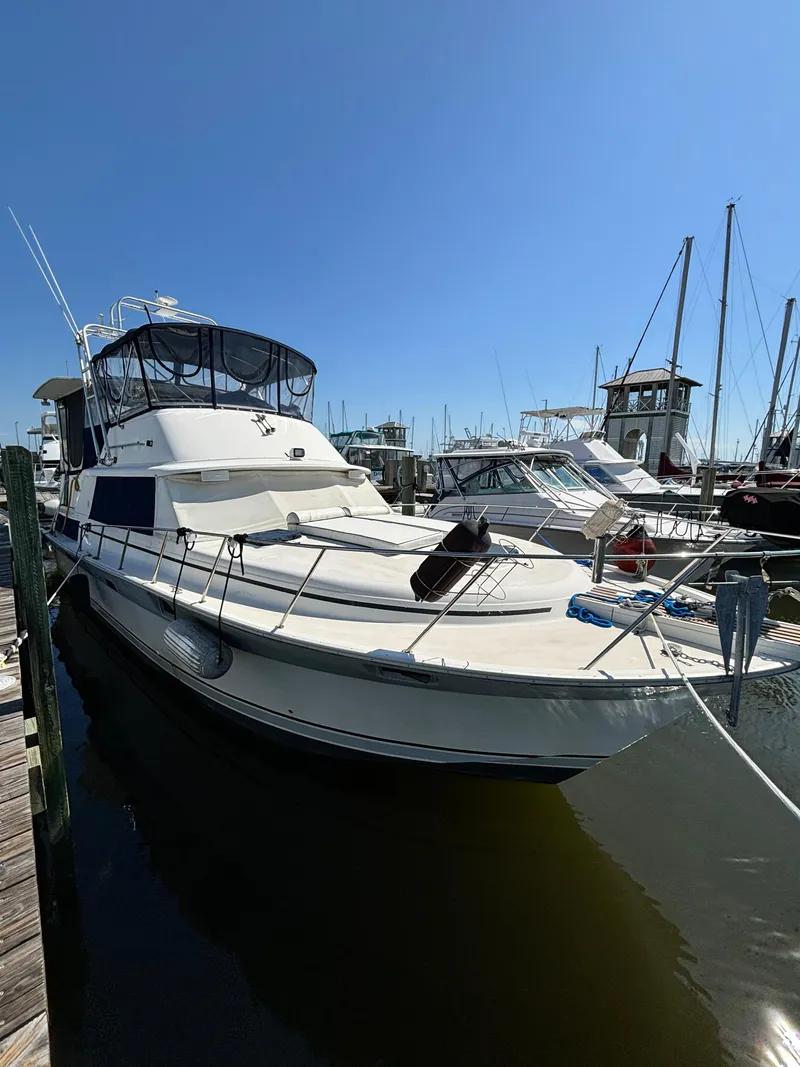 Slide: The Image of 1987 Silverton AFT CABIN yacht docked at marina under clear blue sky. - 1