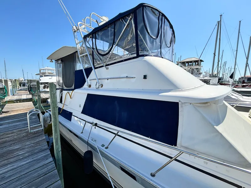 Slide: The Image of 1987 Silverton AFT CABIN yacht docked at marina under clear blue sky. - 2