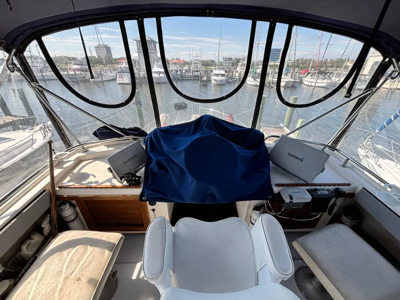 Slide: The Image of 1987 Silverton AFT CABIN helm with Garmin equipment, overlooking marina. - 22