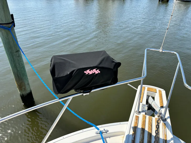 Slide: The Image of 1987 Silverton AFT CABIN boat with covered equipment on deck, docked by water. - 32