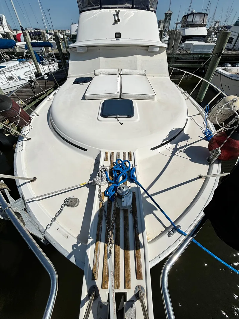 Slide: The Image of 1987 Silverton AFT CABIN yacht docked at marina, featuring spacious deck and mooring lines. - 33