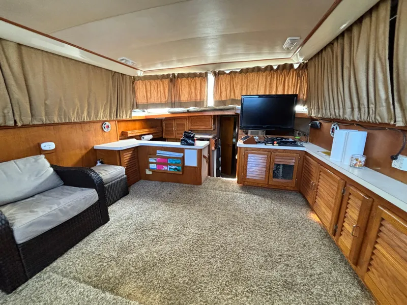 Slide: The Image of Interior of 1987 Silverton AFT CABIN yacht with cozy seating and TV. - 42
