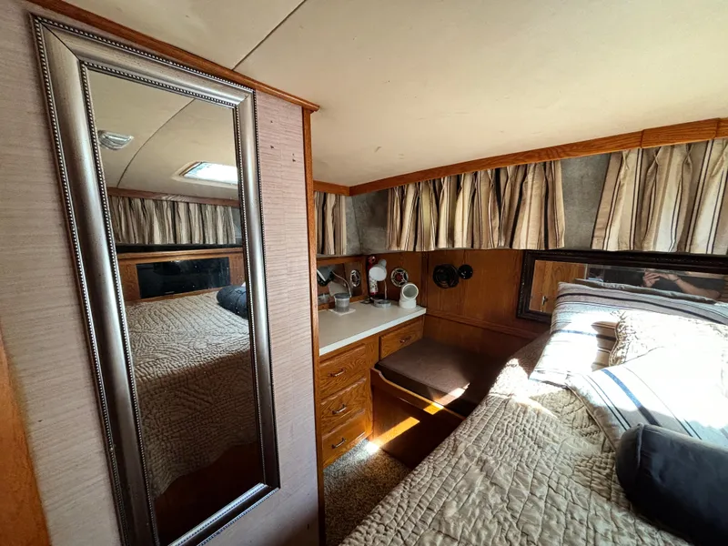 Slide: The Image of 1987 Silverton AFT CABIN interior with bed, mirror, and wooden cabinetry. - 48