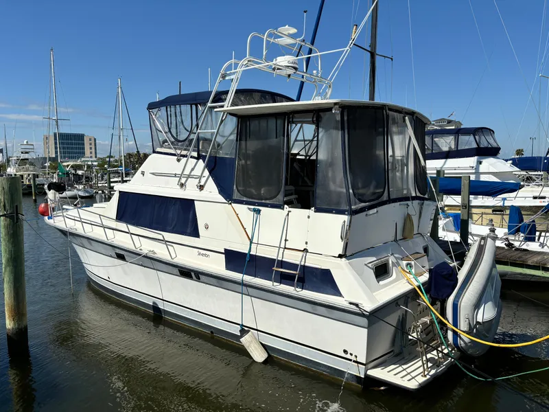 Slide: The Image of 1987 Silverton AFT CABIN yacht docked at marina under clear blue sky. - 6