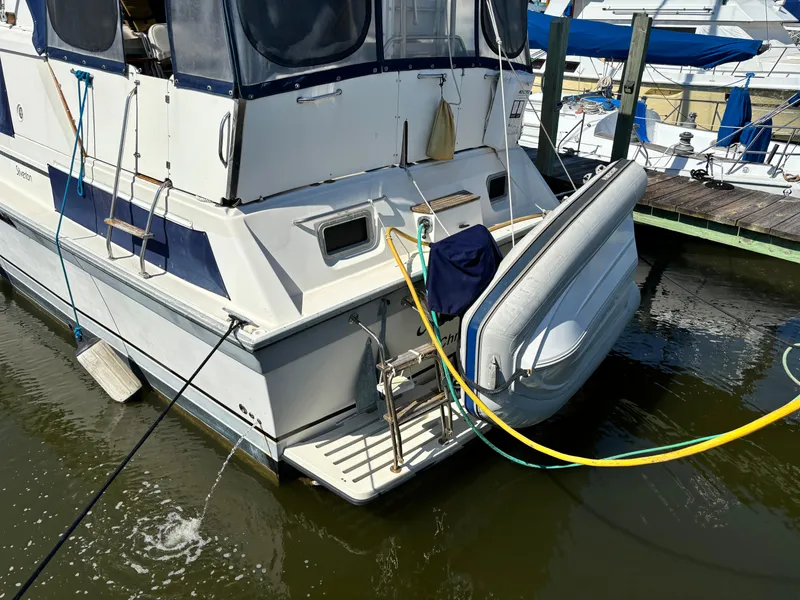 Slide: The Image of 1987 Silverton AFT CABIN boat docked with inflatable dinghy attached. - 8