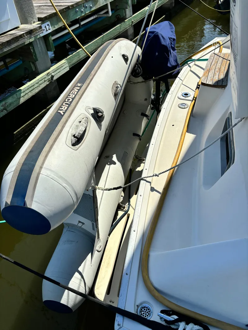 Slide: The Image of 1987 Silverton AFT CABIN with Mercury inflatable boat docked at marina. - 9
