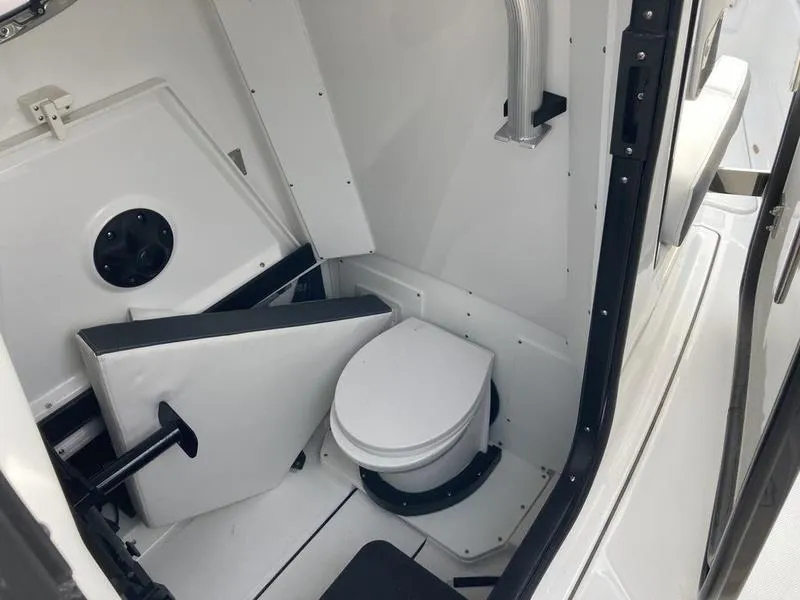 Slide: The Image of 2023 Blackfin 302CC boat interior with a compact marine toilet. - 12