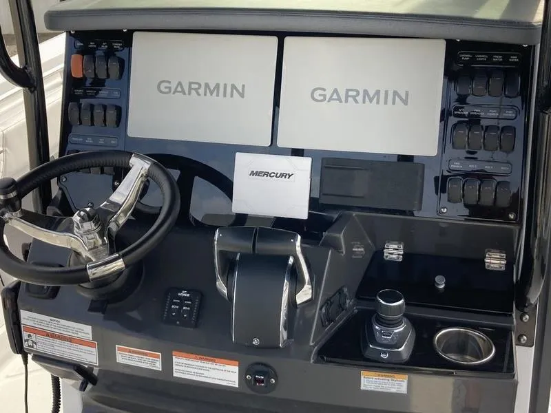 Slide: The Image of 2023 Blackfin 302CC boat dashboard with dual Garmin displays and Mercury controls. - 3