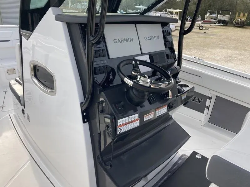 Slide: The Image of 2023 Blackfin 302CC boat console with dual Garmin displays and steering wheel. - 4