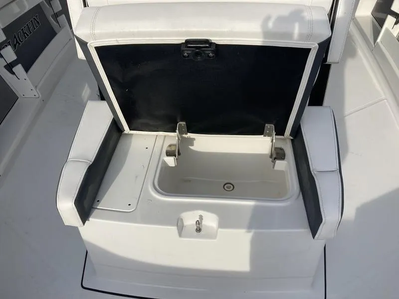 Slide: The Image of 2023 Blackfin 302CC boat seat with storage compartment open. - 6