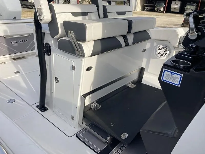 Slide: The Image of 2023 Blackfin 302CC boat interior with cushioned seating and storage compartments. - 8