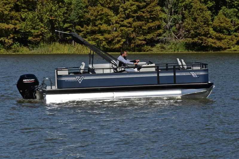 Slide: The Image of 2023 Viaggio DM20F pontoon boat cruising on a lake with a Mercury outboard motor. - 6