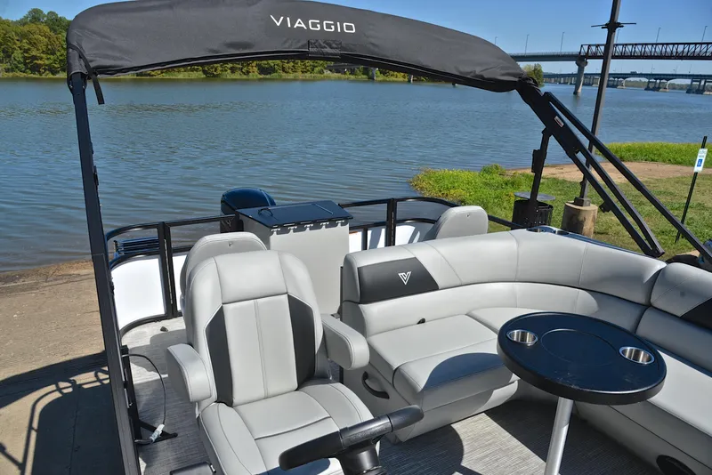 Slide: The Image of 2023 Viaggio DM18F pontoon boat with seating and table, docked by a river. - 22