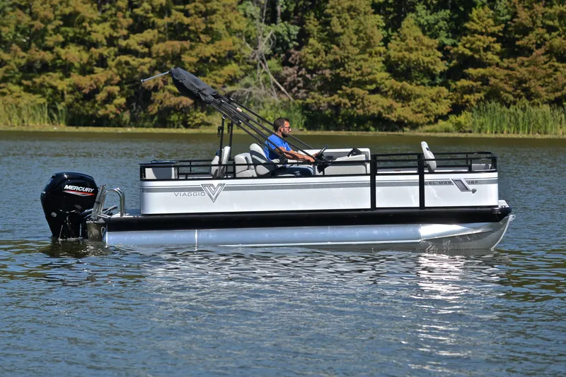 Slide: The Image of 2023 Viaggio DM18F pontoon boat on a lake with a Mercury outboard motor. - 6