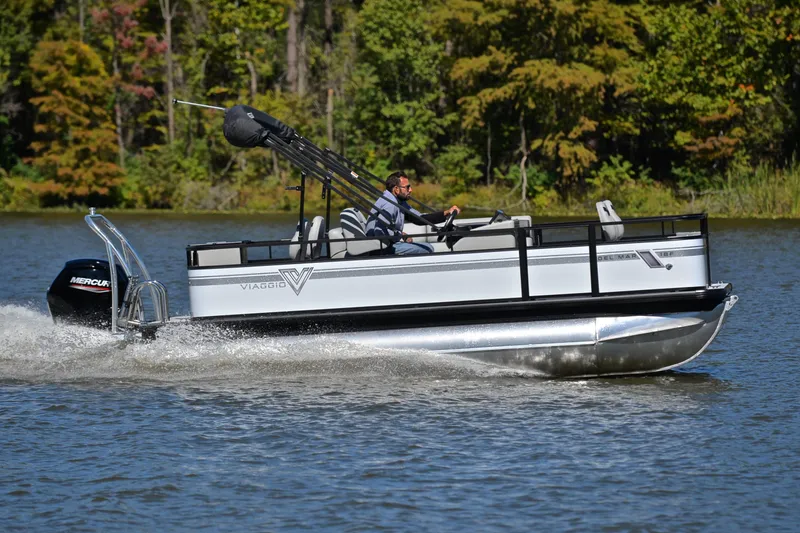 Slide: The Image of 2023 Viaggio DM18F pontoon boat cruising on a lake with lush green trees in the background. - 3