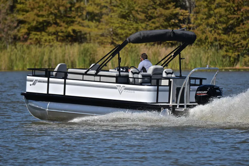 Slide: The Image of 2023 Viaggio DM18F pontoon boat cruising on a lake with lush greenery in the background. - 4