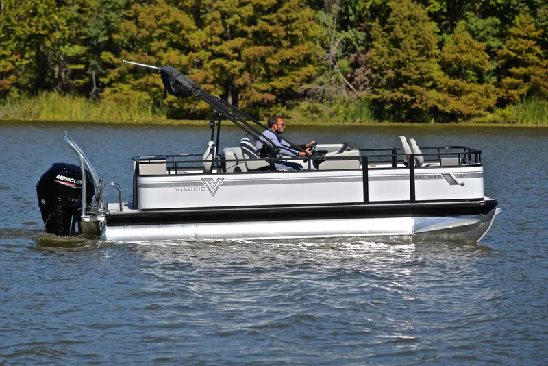Slide: The Image of 2023 Viaggio DM18F pontoon boat cruising on a lake with lush green trees in the background. - 6