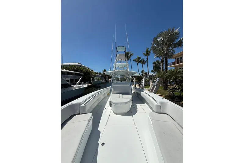 Slide: The Image of 2023 Contender 44 ST boat docked, featuring spacious deck and tower under clear blue sky. - 23