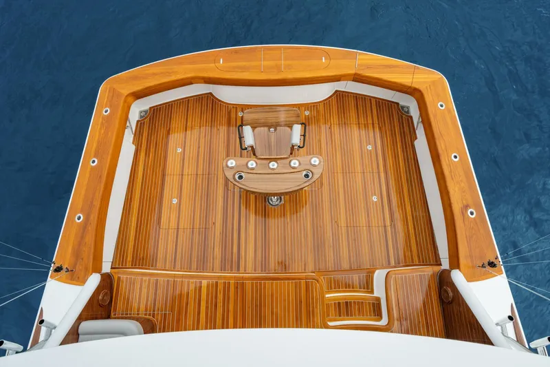 Slide: The Image of 2025 Viking 82 Convertible yacht deck with polished wood finish, viewed from above. - 27