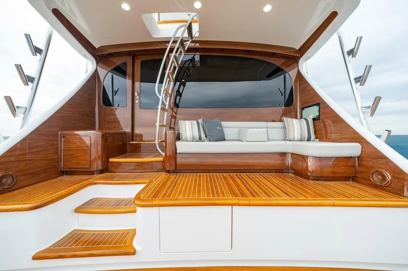 Slide: The Image of Luxurious 2025 Viking 82 Convertible yacht with elegant wooden deck and seating area. - 29