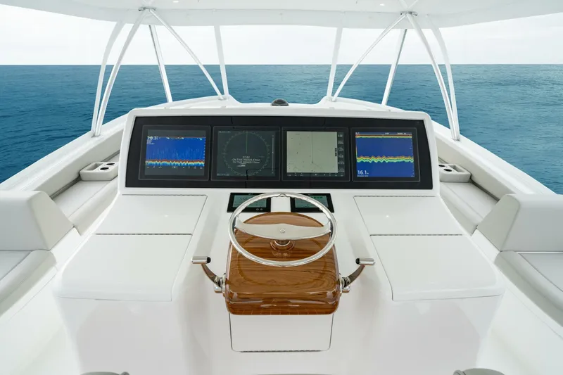Slide: The Image of 2025 Viking 82 Convertible yacht helm with advanced navigation displays, steering wheel, and ocean view. - 40